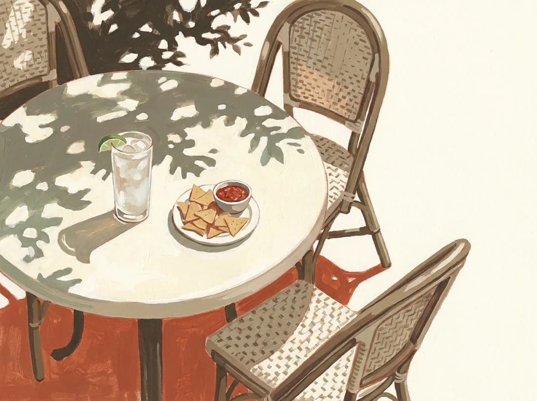An Austin patio table set with chips, salsa, and a cold drink in dappled afternoon light