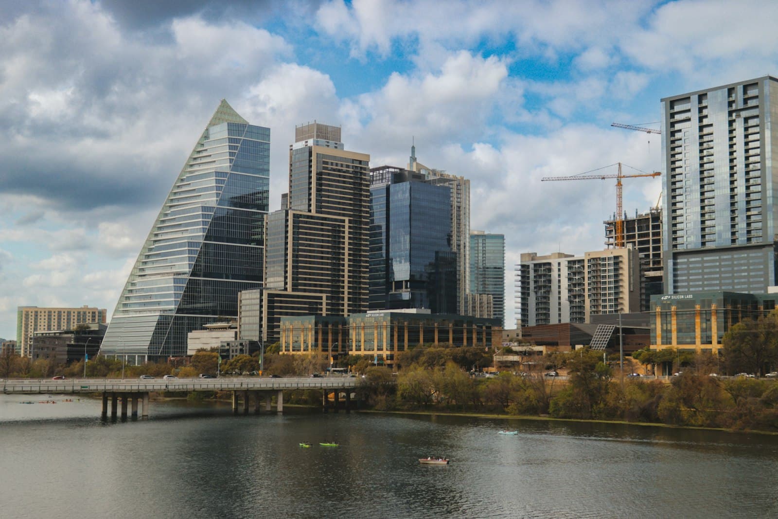 The downtown Austin skyline over Lady Bird Lake, with kayakers on the water.