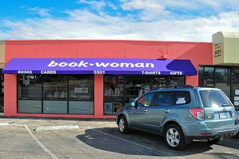 The BookWoman storefront on North Lamar, its purple awning reading book woman over windows of books, cards, t-shirts, and gifts.